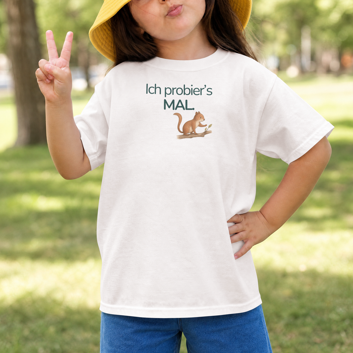 Mädchen zeigt das Victory Zeichen und trägt ein weißes Kinder T-Shirt mit einem Eichhörnchen und dem Sprcuh Ich probier's mal