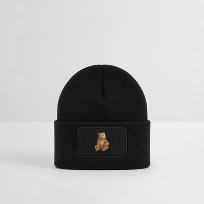Kinder Beanie mit dem Bär in schwarz, stht auf eiem Tisch