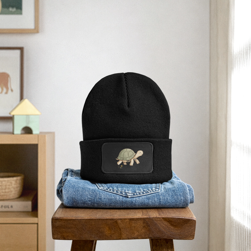 Kinder Beanie mit dem Schildkröte in schwarz, steht auf einer jeans